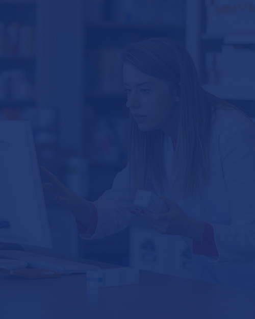 Pharmacist making prescription record through computer in pharmacy